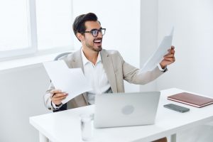 Laptop paper holding company planning suit technology happy office document businessman